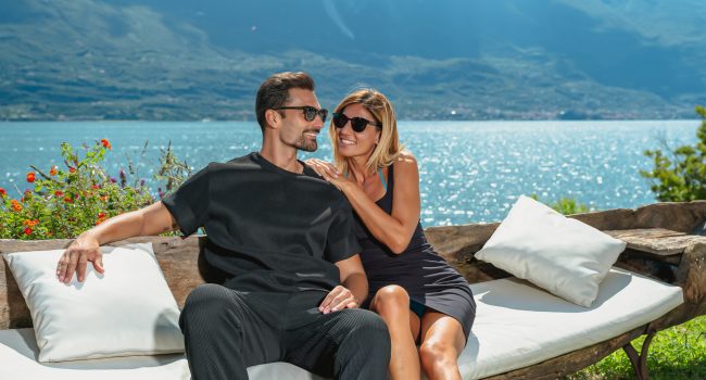 Coppia in area relax esterna con sfondo lago di Garda